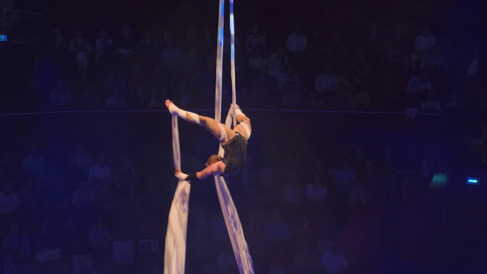 La contorsionniste sur ses tissus aériens